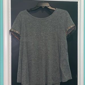 Gray tee with embroidered sleeves.
